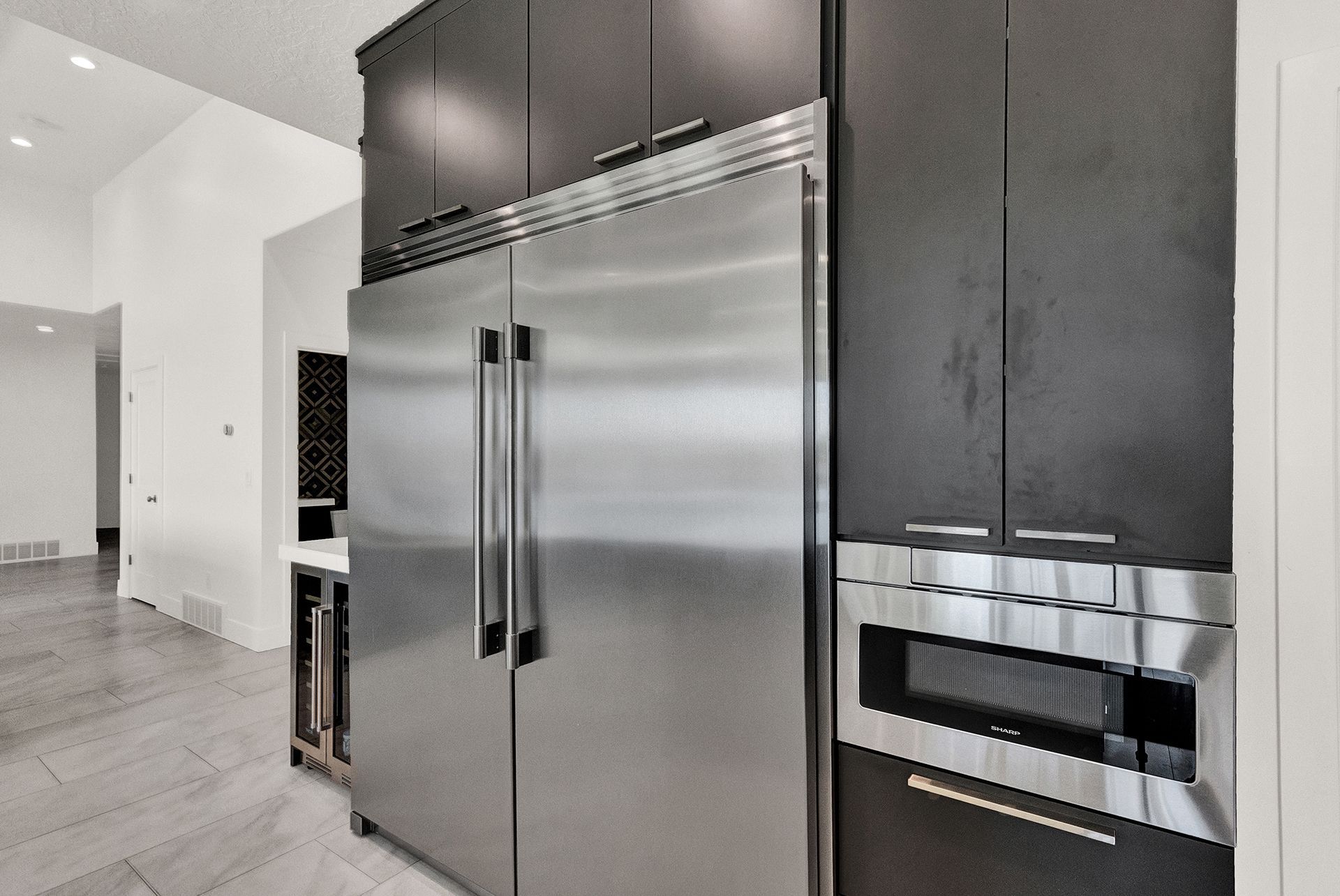 A kitchen with stainless steel appliances and black cabinets.