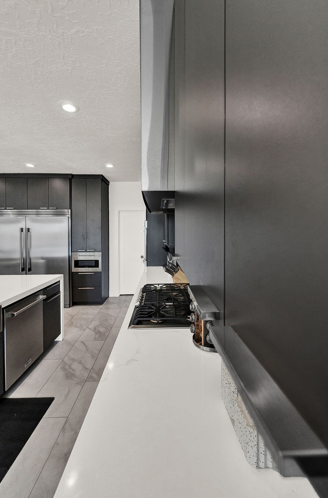 A kitchen with stainless steel appliances and a stove top oven.