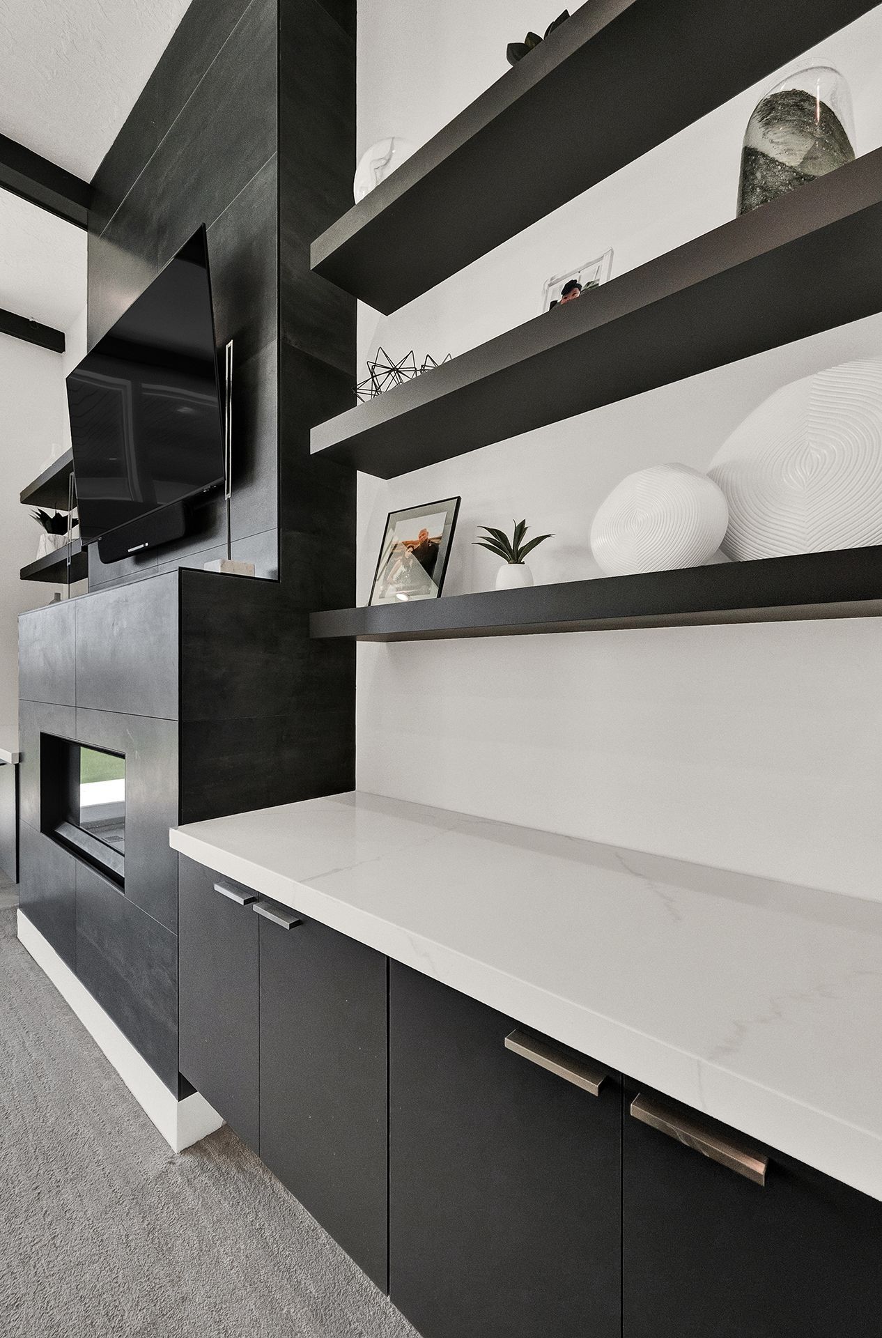 A living room with black cabinets and shelves and a fireplace.
