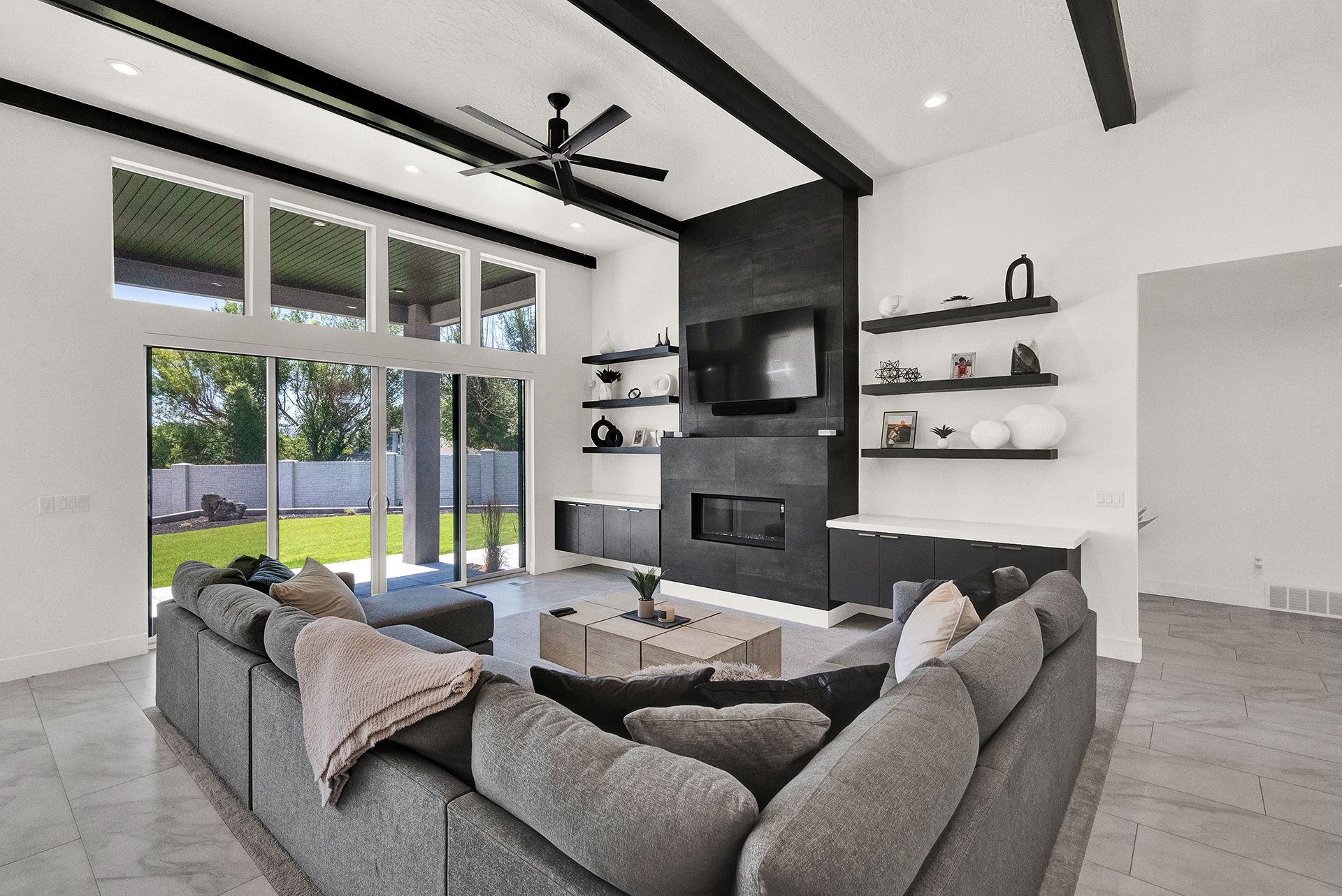 A living room with a large sectional couch and a fireplace