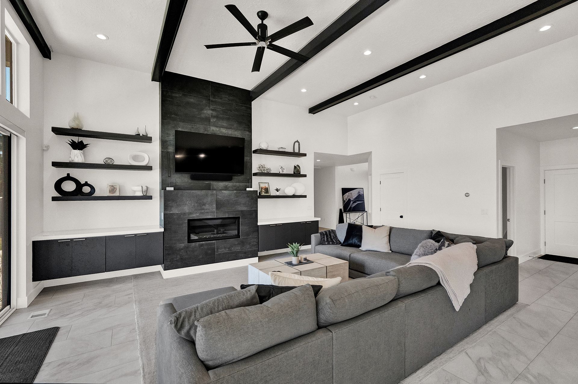 A living room with a couch , fireplace , television and ceiling fan.