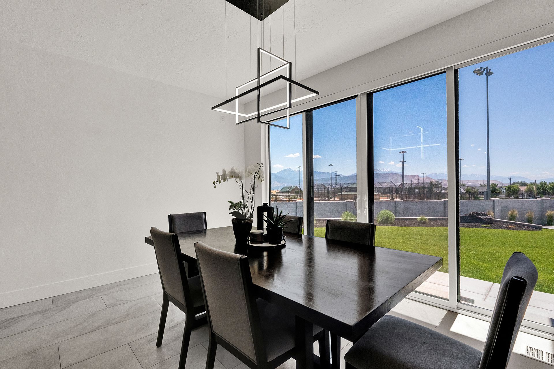 A dining room with a table and chairs and a large window.
