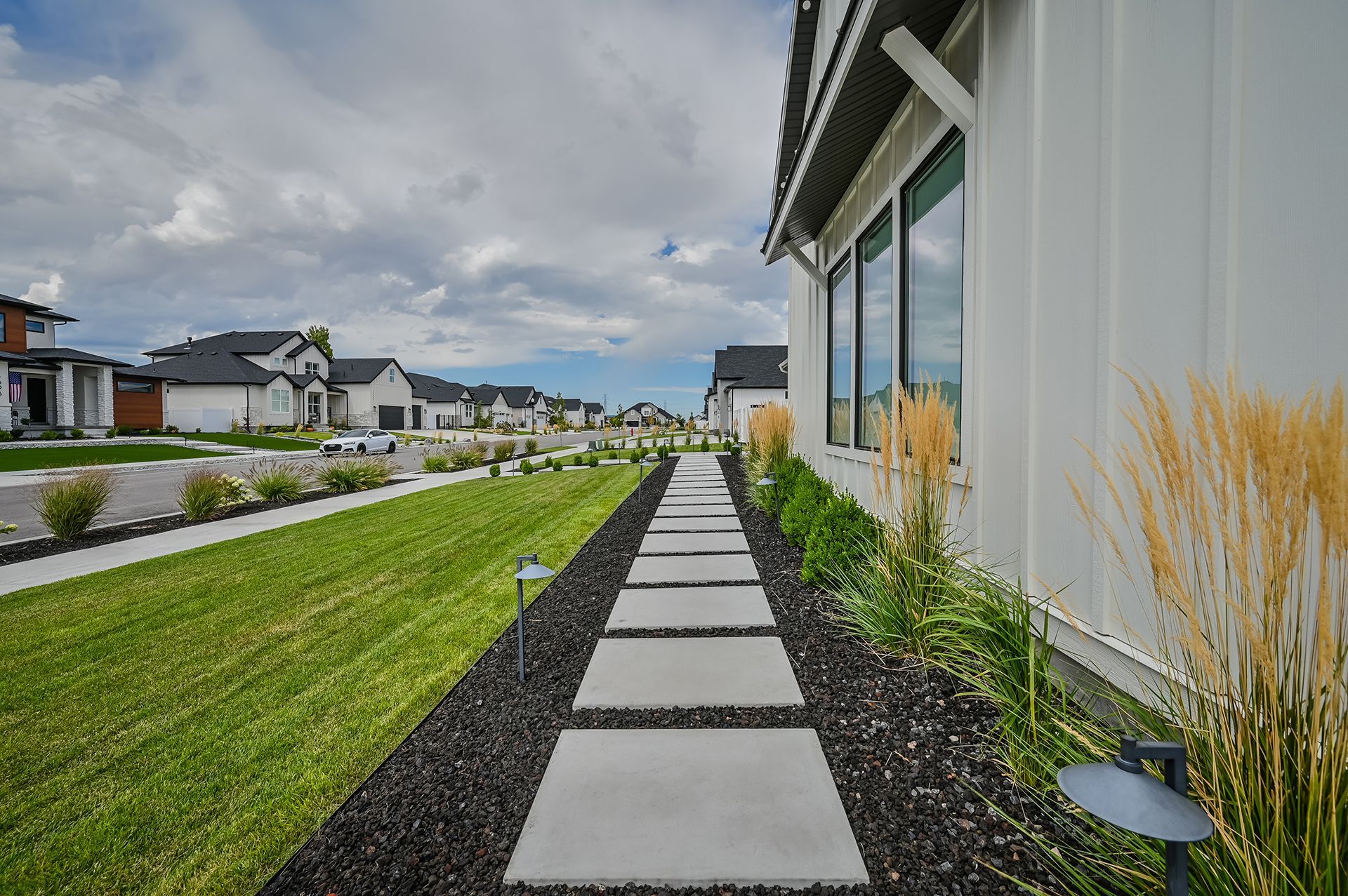 A walkway leading to a house in a residential neighborhood.