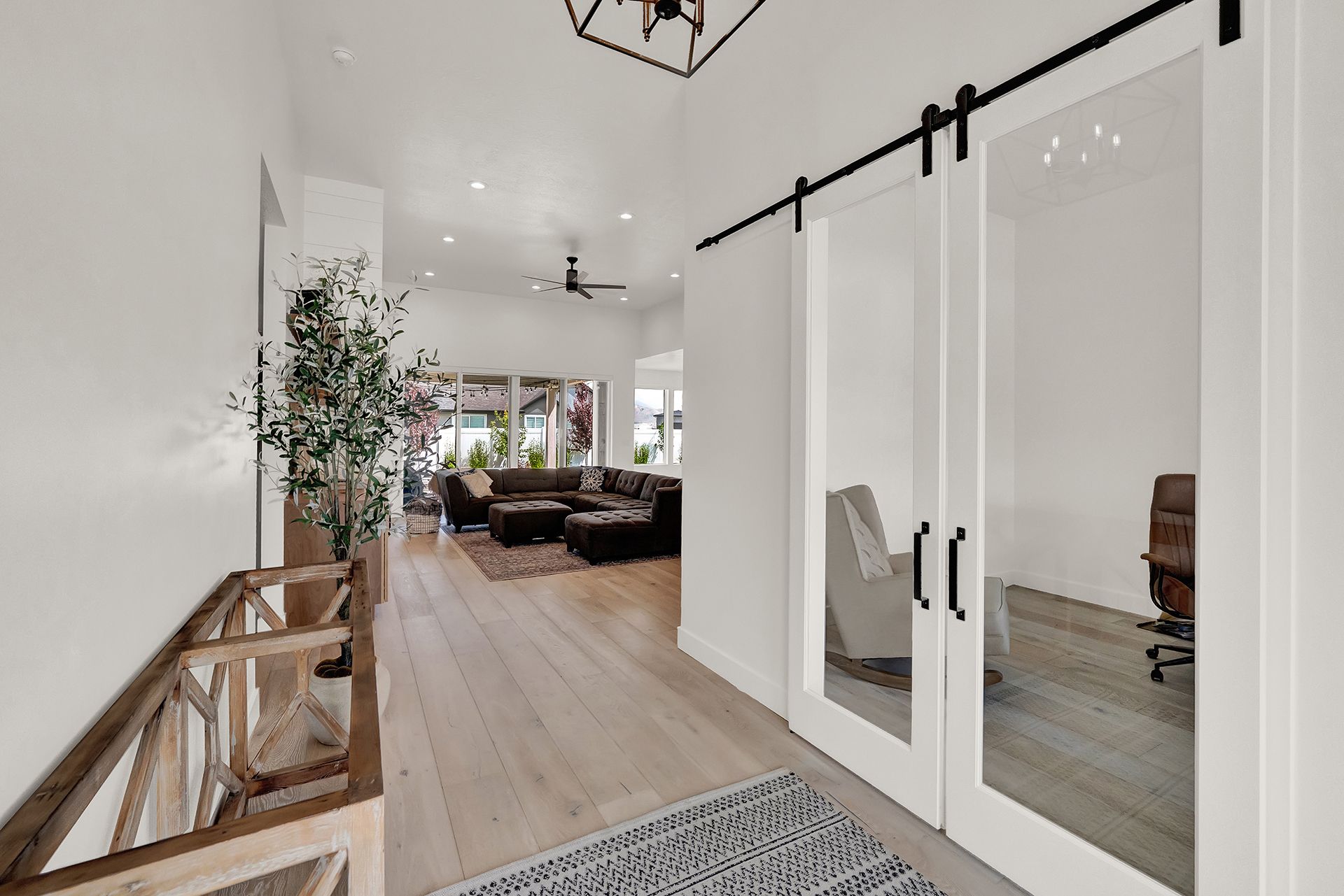 A hallway with sliding barn doors leading to a living room.