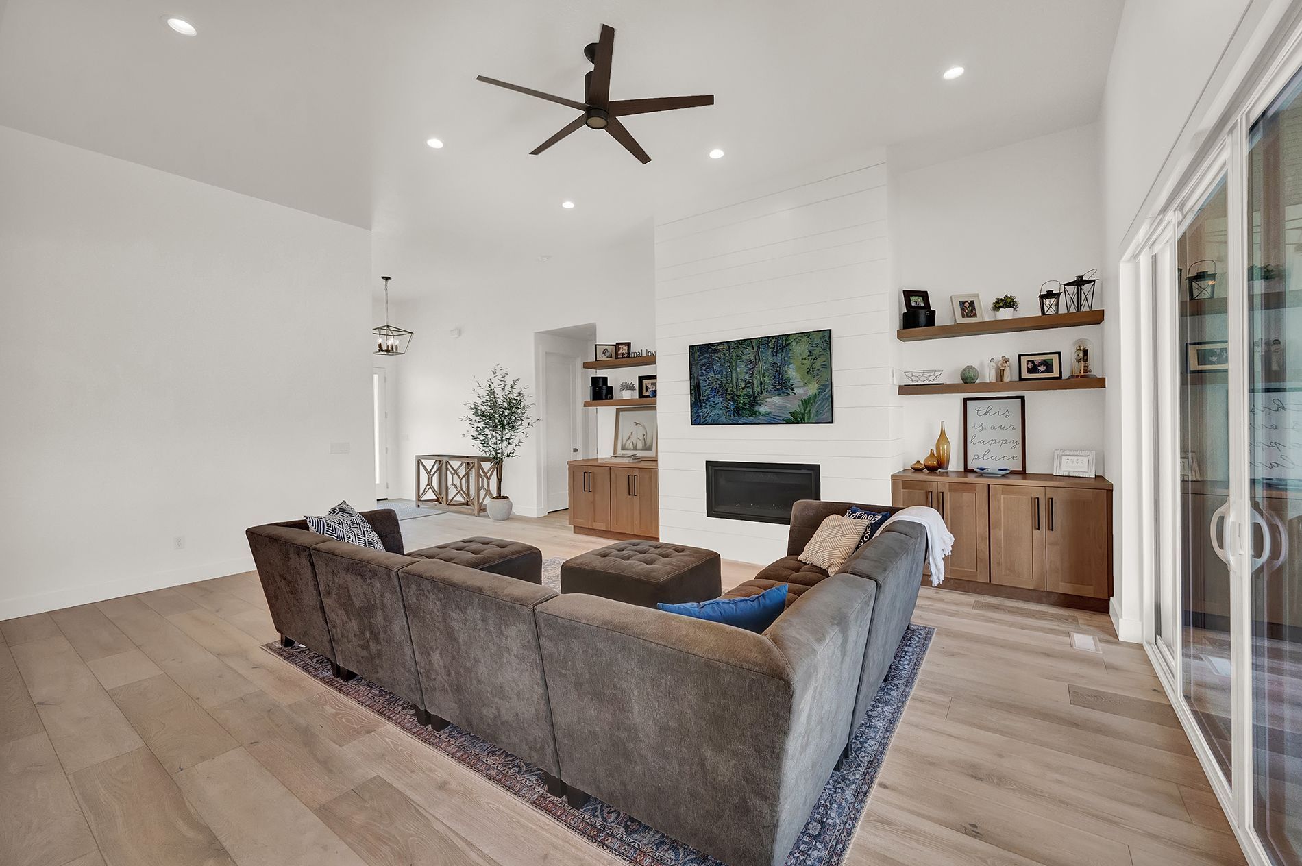 A living room with a couch , fireplace and ceiling fan.