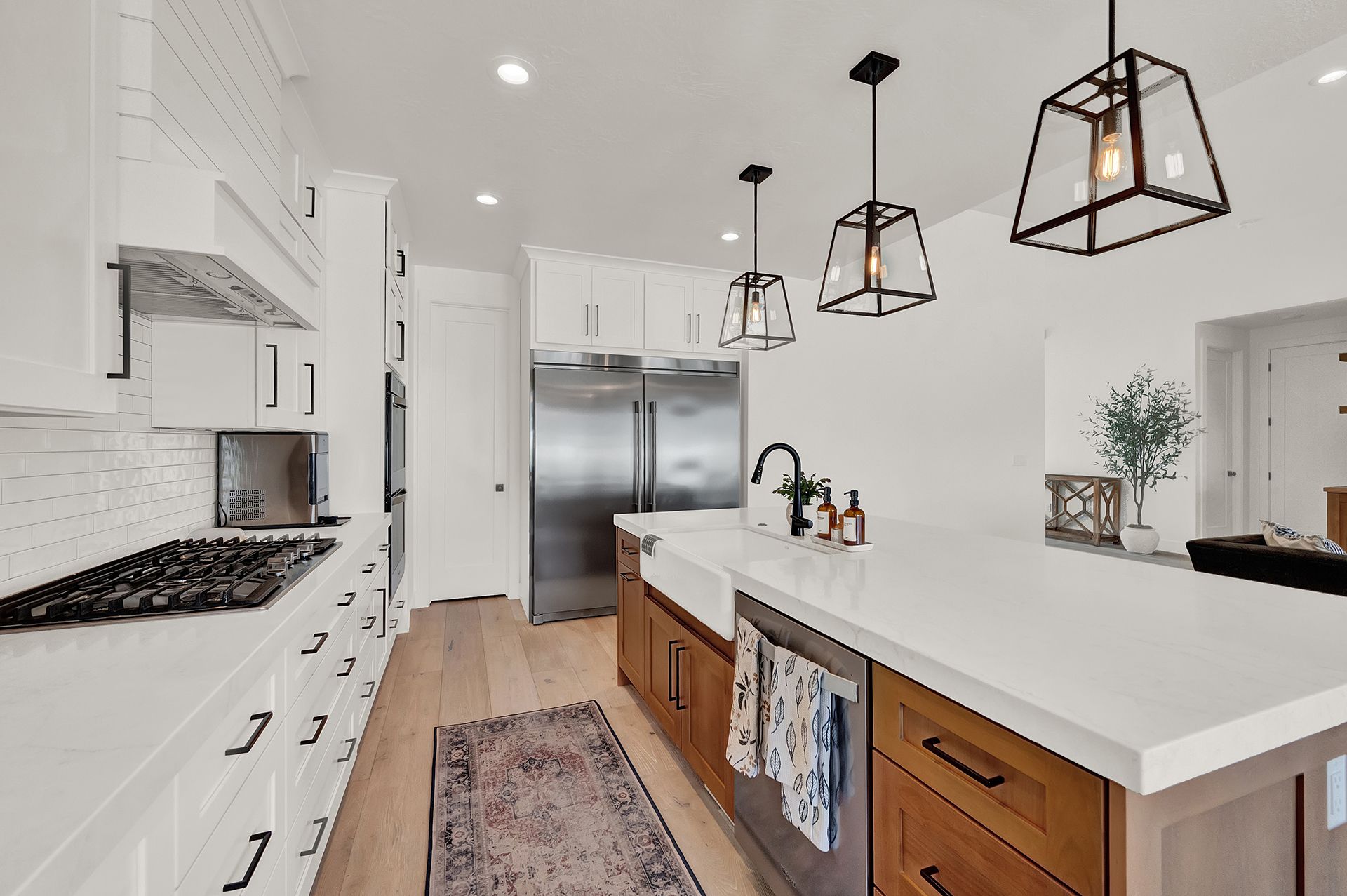 A kitchen with white cabinets , stainless steel appliances , and a large island.