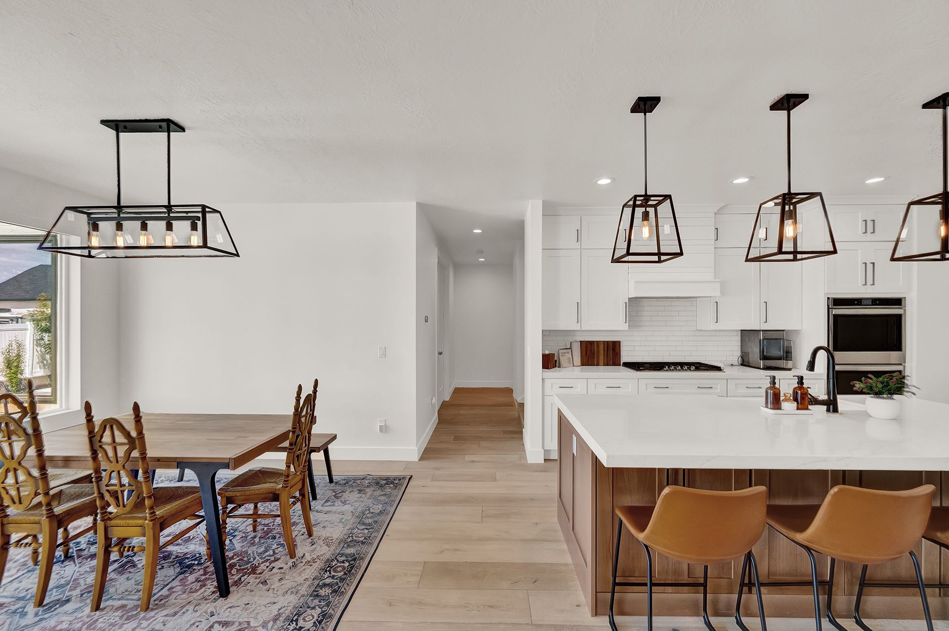 A kitchen and dining room in a house with a table and chairs.