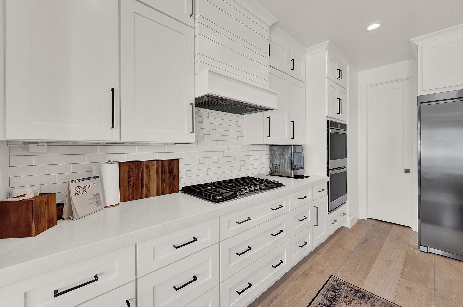 A kitchen with white cabinets and stainless steel appliances.