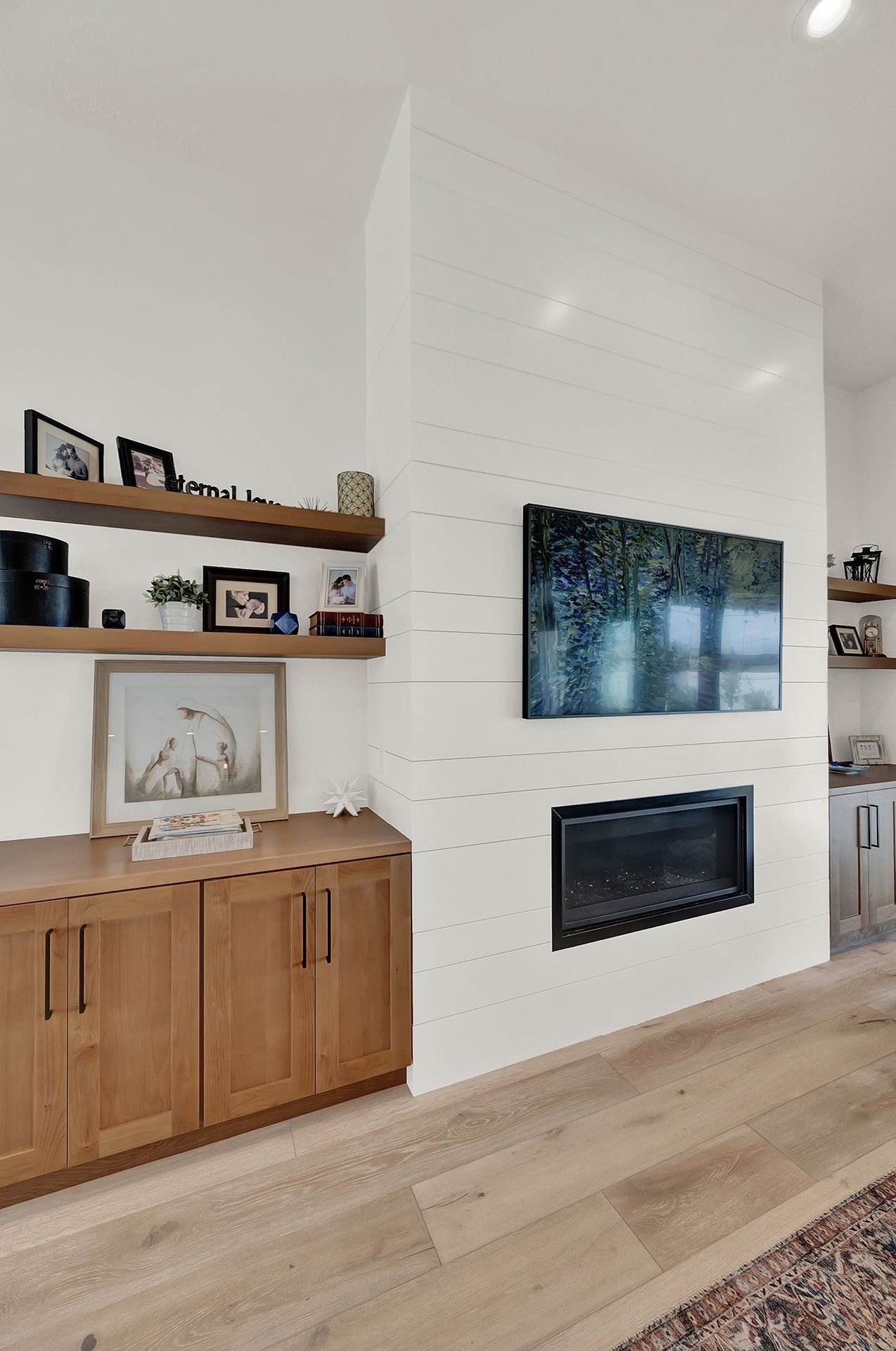 A living room with a fireplace and a flat screen tv on the wall.