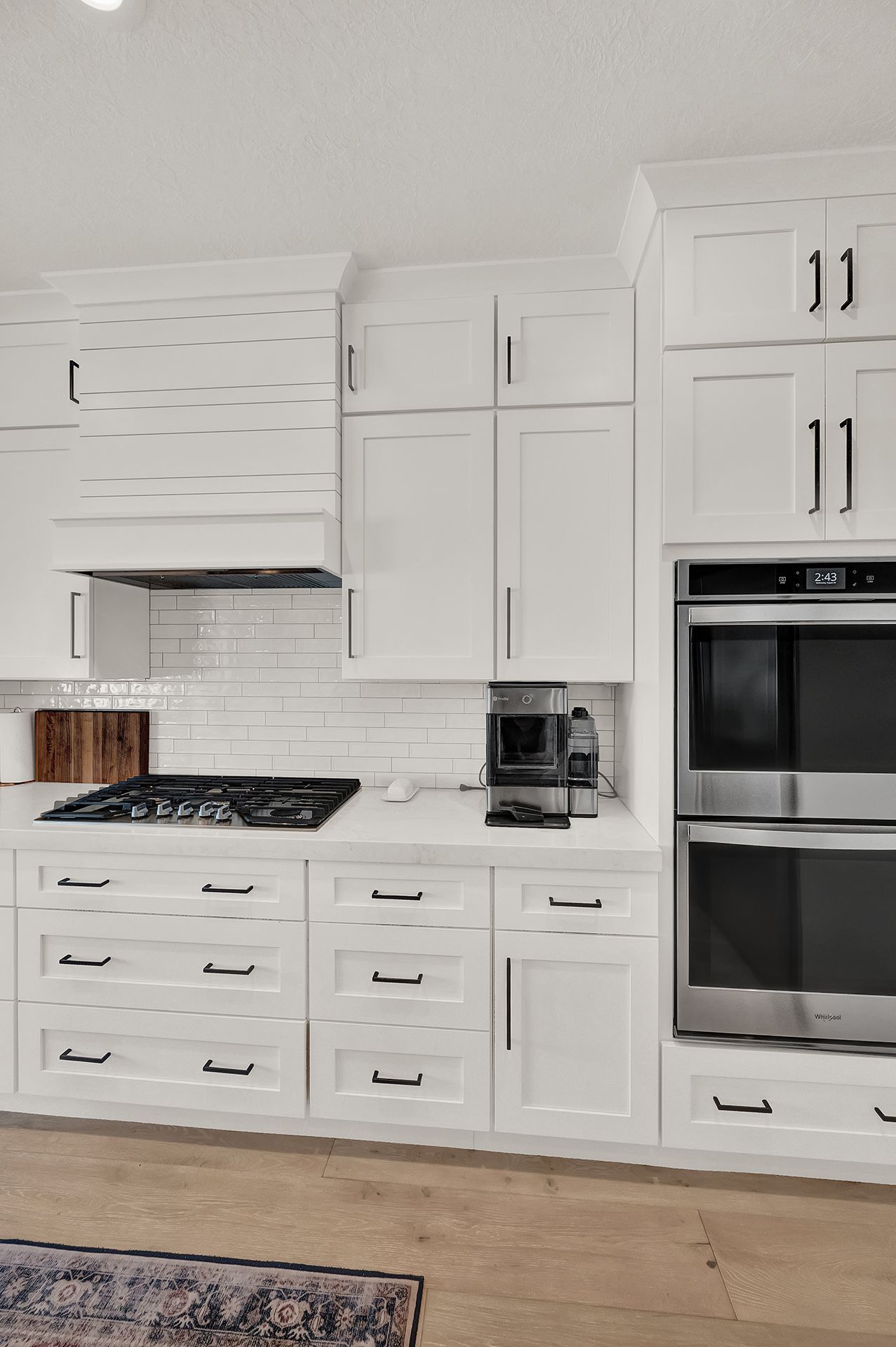 A kitchen with white cabinets and stainless steel appliances.