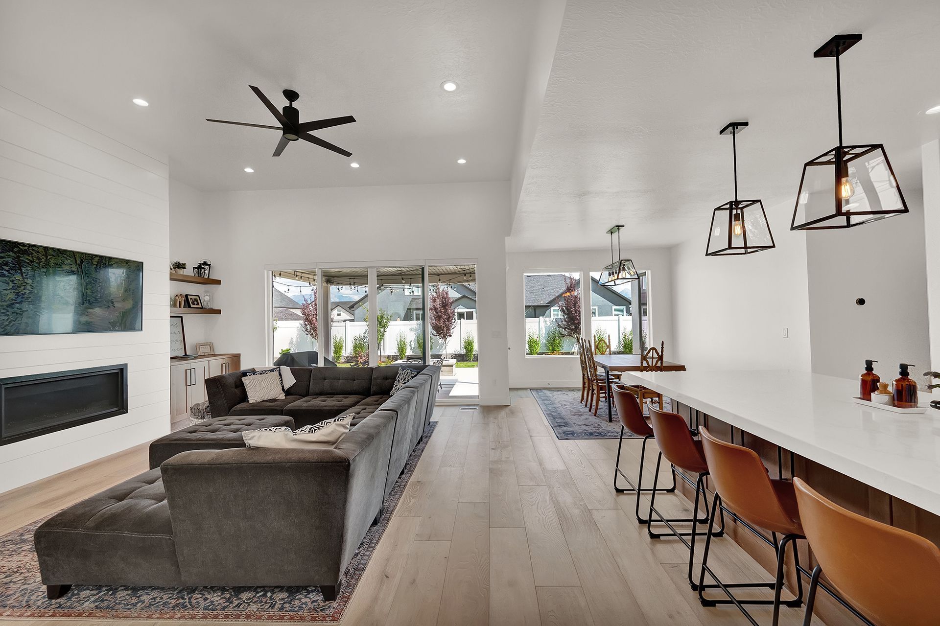 A living room with a large couch and a ceiling fan