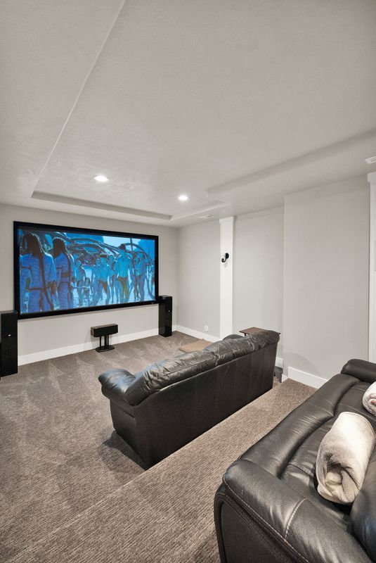 A living room with a couch and a projector screen.