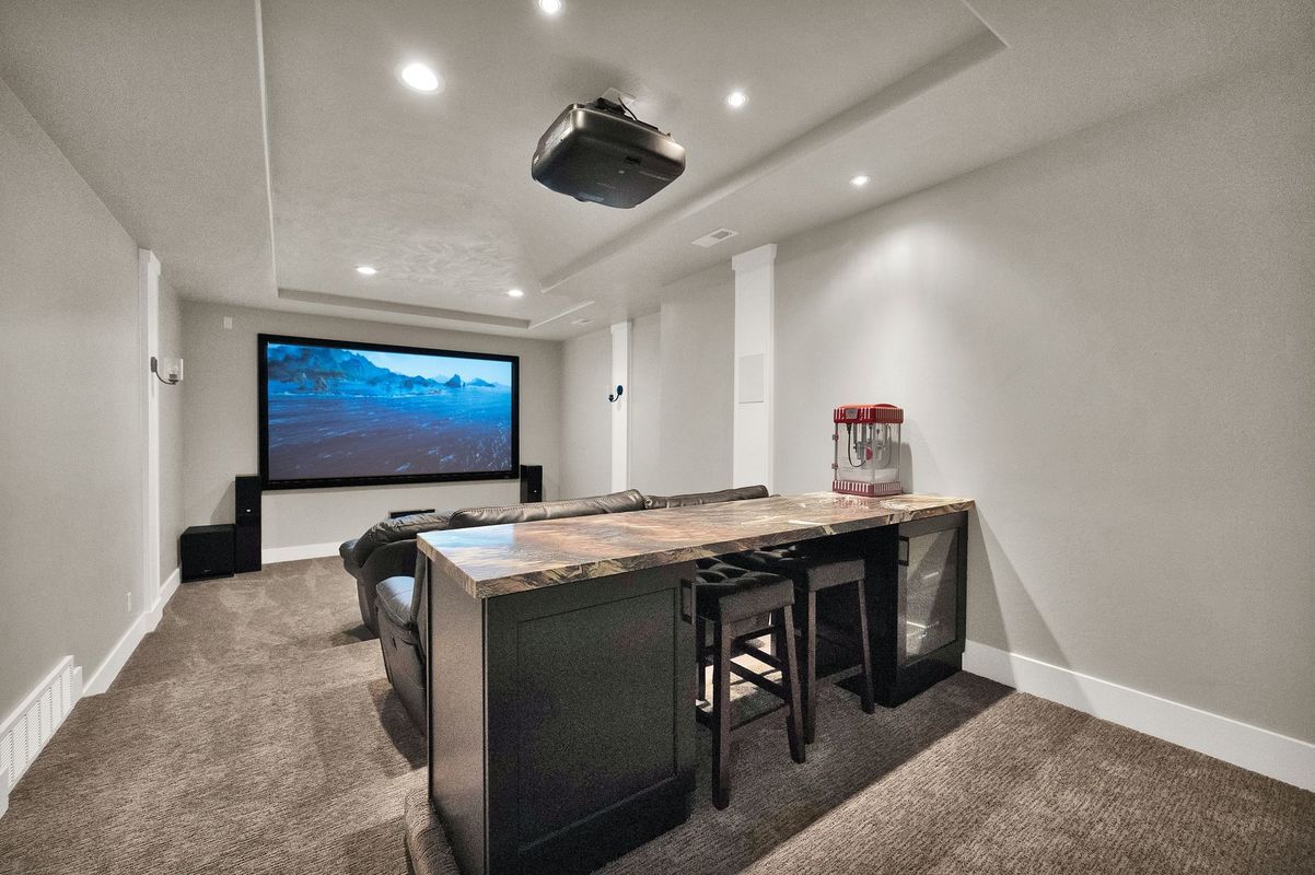 A home theater with a large screen and a popcorn machine.