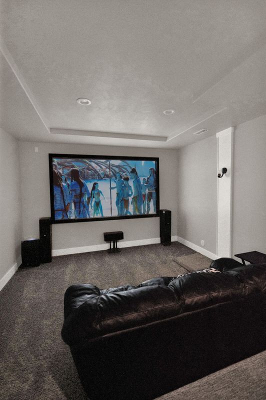 A home theater with a large screen and a couch.