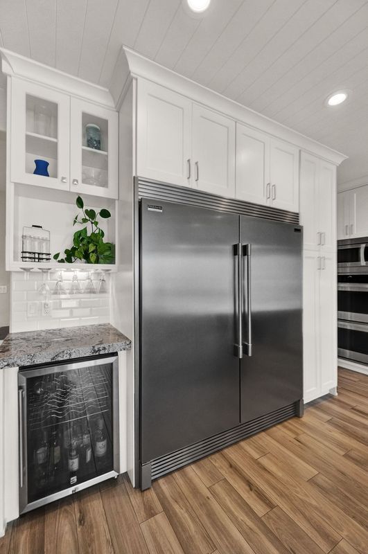 A kitchen with a stainless steel refrigerator and a wine cooler.