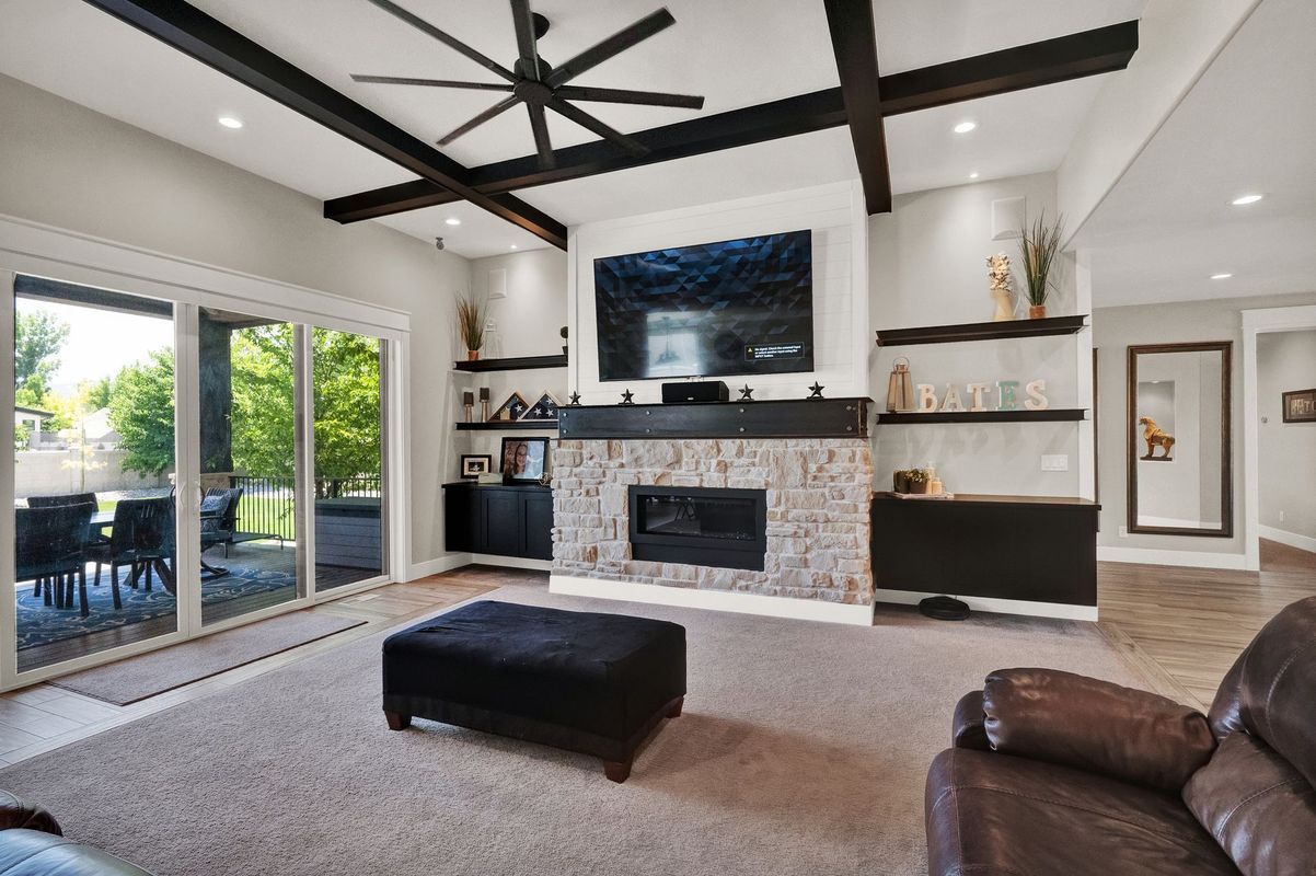 A living room with a fireplace , couch , ottoman and television.