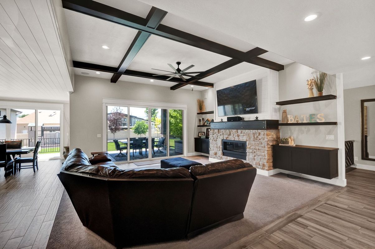 A living room with a couch , fireplace , television and sliding glass doors.