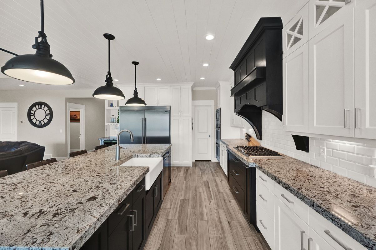A kitchen with granite counter tops and black cabinets