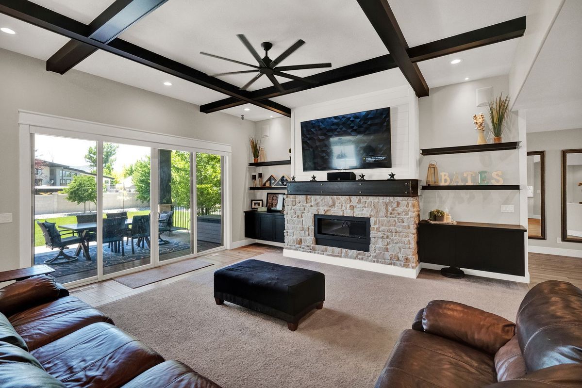 A living room with a couch , chair , fireplace and television.