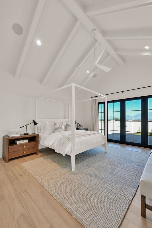 A bedroom with a canopy bed and a ceiling fan