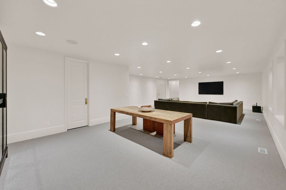 A living room with a table and a television on the wall.