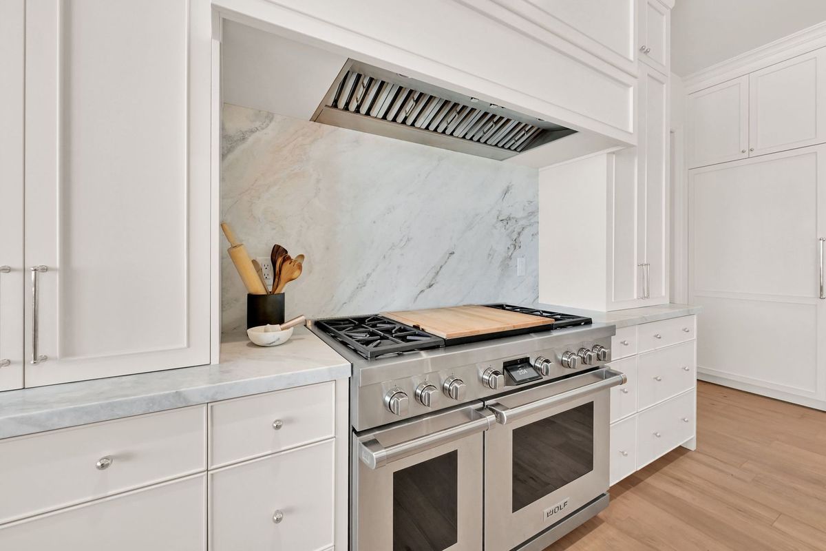 A kitchen with stainless steel appliances and white cabinets.