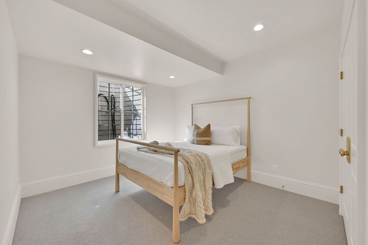 A bedroom with a bed , window and carpet.