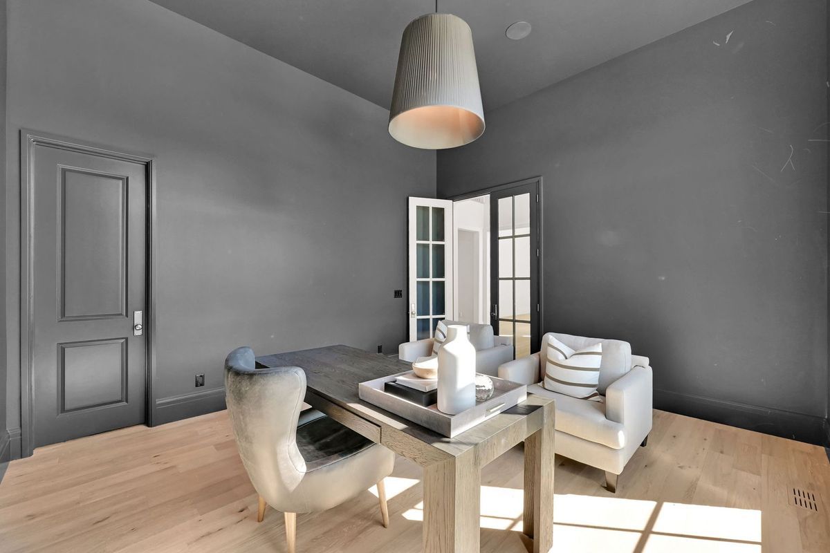 A living room with gray walls and a desk and chairs