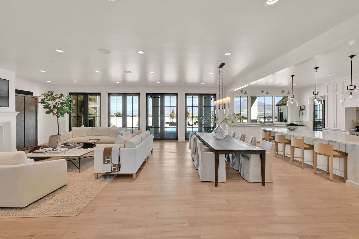 A living room , dining room , and kitchen in a large house.
