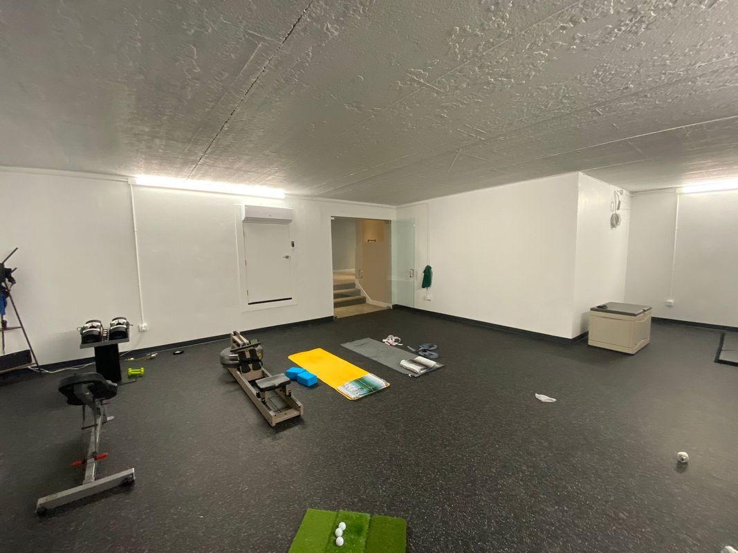 A large room with a lot of exercise equipment in it.