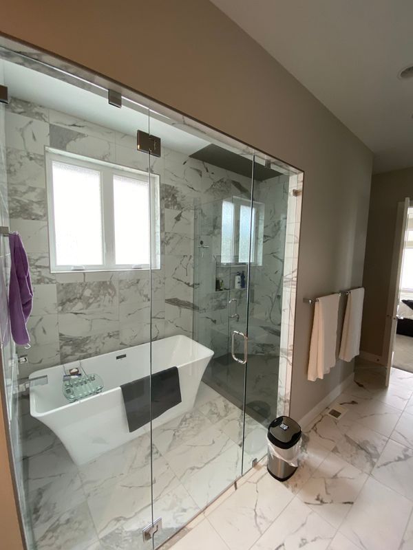 A bathroom with a bathtub and a glass shower door