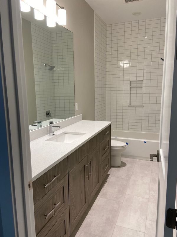 A bathroom with two sinks , a toilet , and a bathtub.