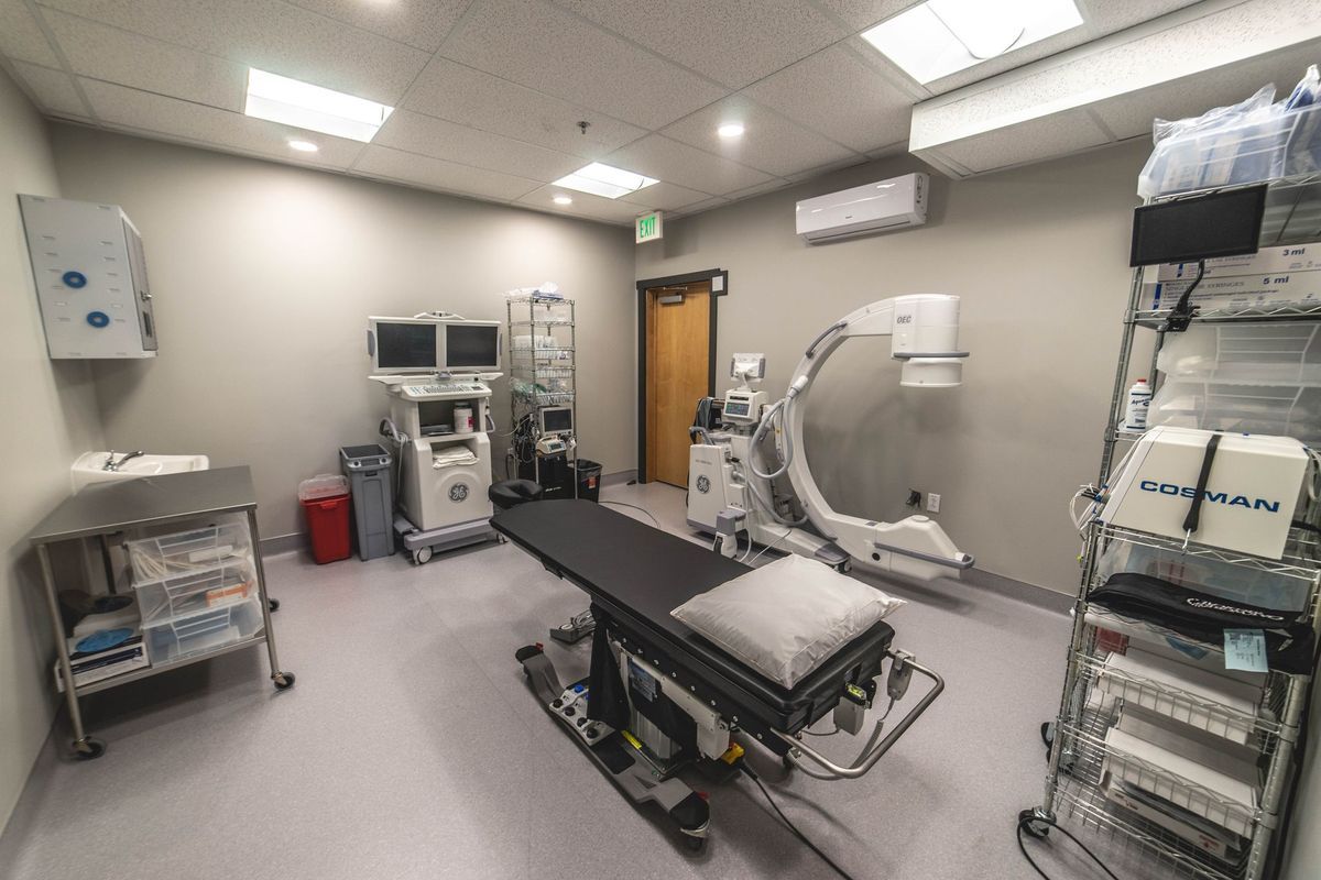 An operating room with a bed , monitors , and other medical equipment.