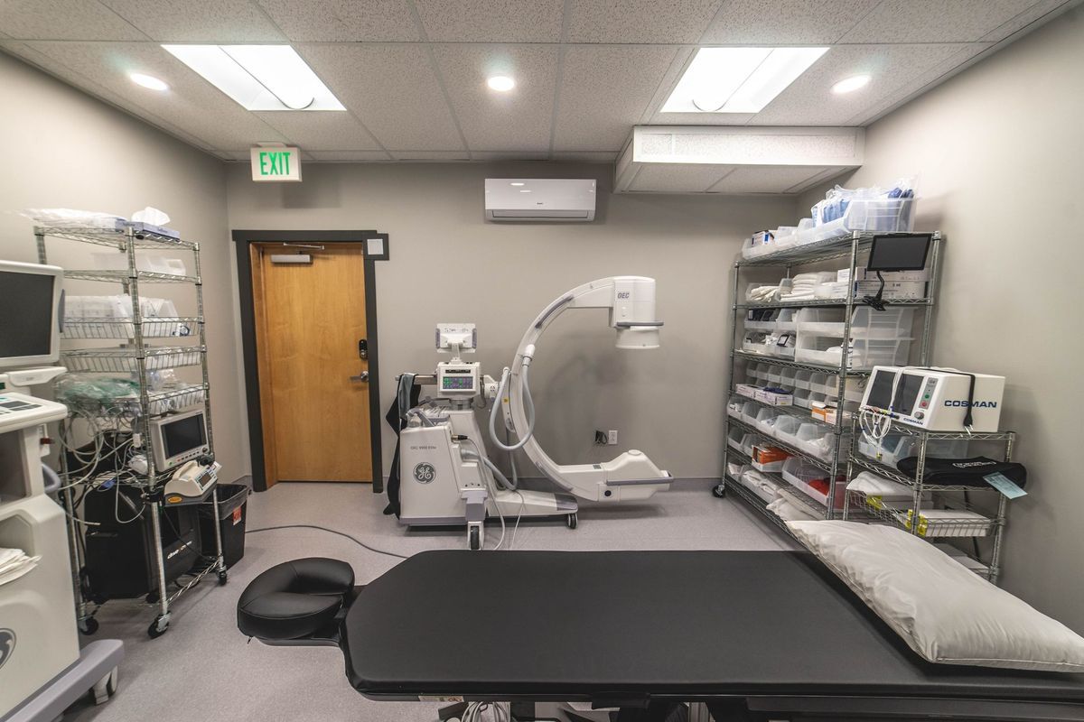 A hospital room with a surgical table and a ct scan machine.