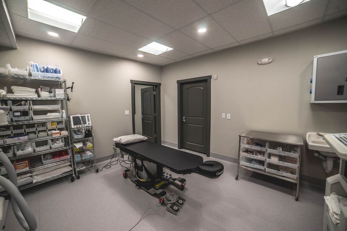 There is a surgical table in the middle of the room.