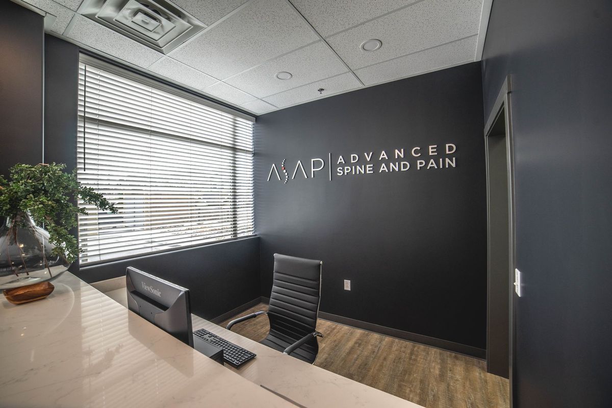 A reception area with a desk and chairs and a sign on the wall.