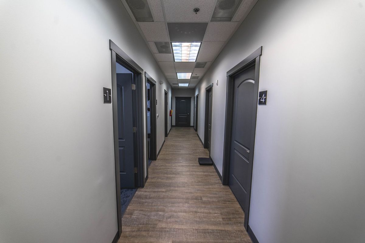 A long hallway with a lot of doors in a building.