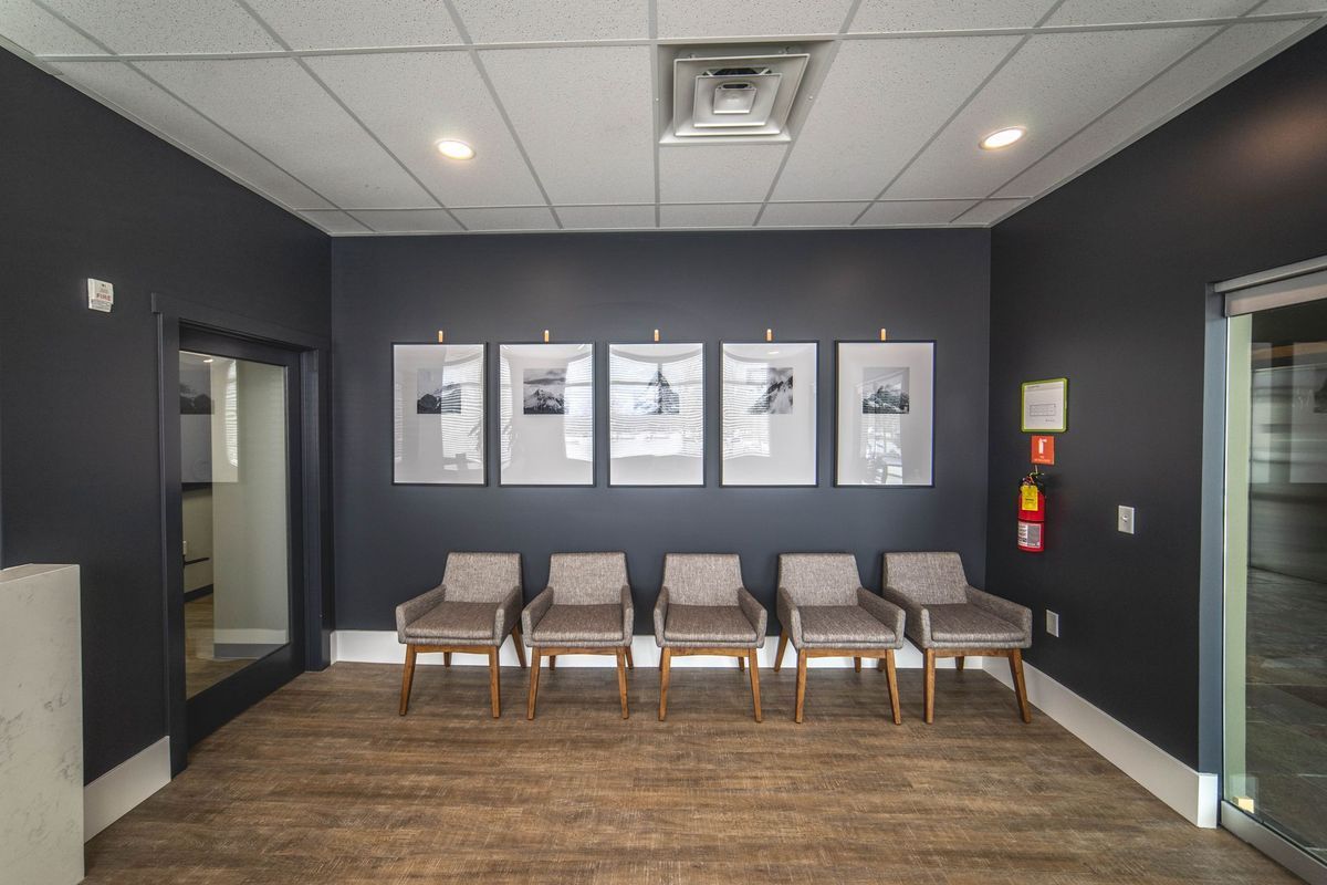A waiting room with chairs and pictures on the wall