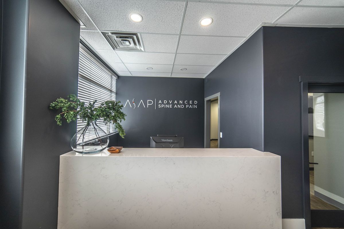 A reception desk in an office with a plant on it.