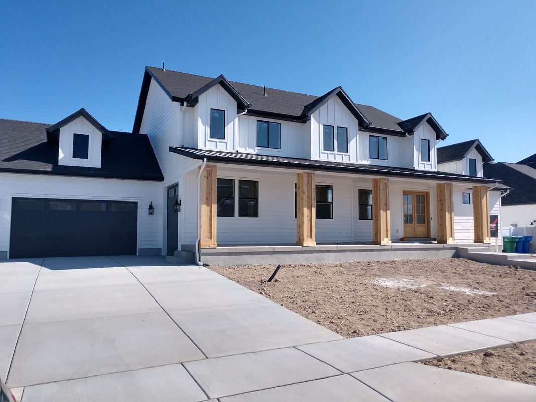 A large white house with a black garage door