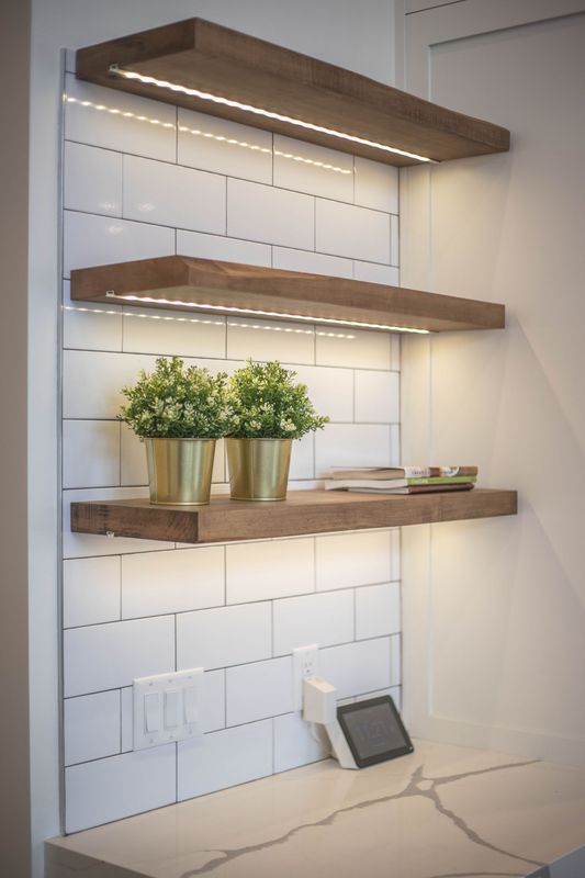 A wooden shelf with two potted plants on it