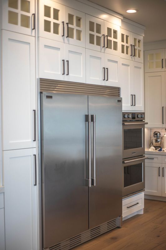 A kitchen with stainless steel appliances and white cabinets.