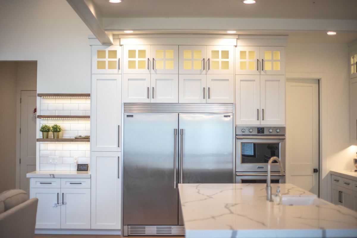 A kitchen with stainless steel appliances and white cabinets