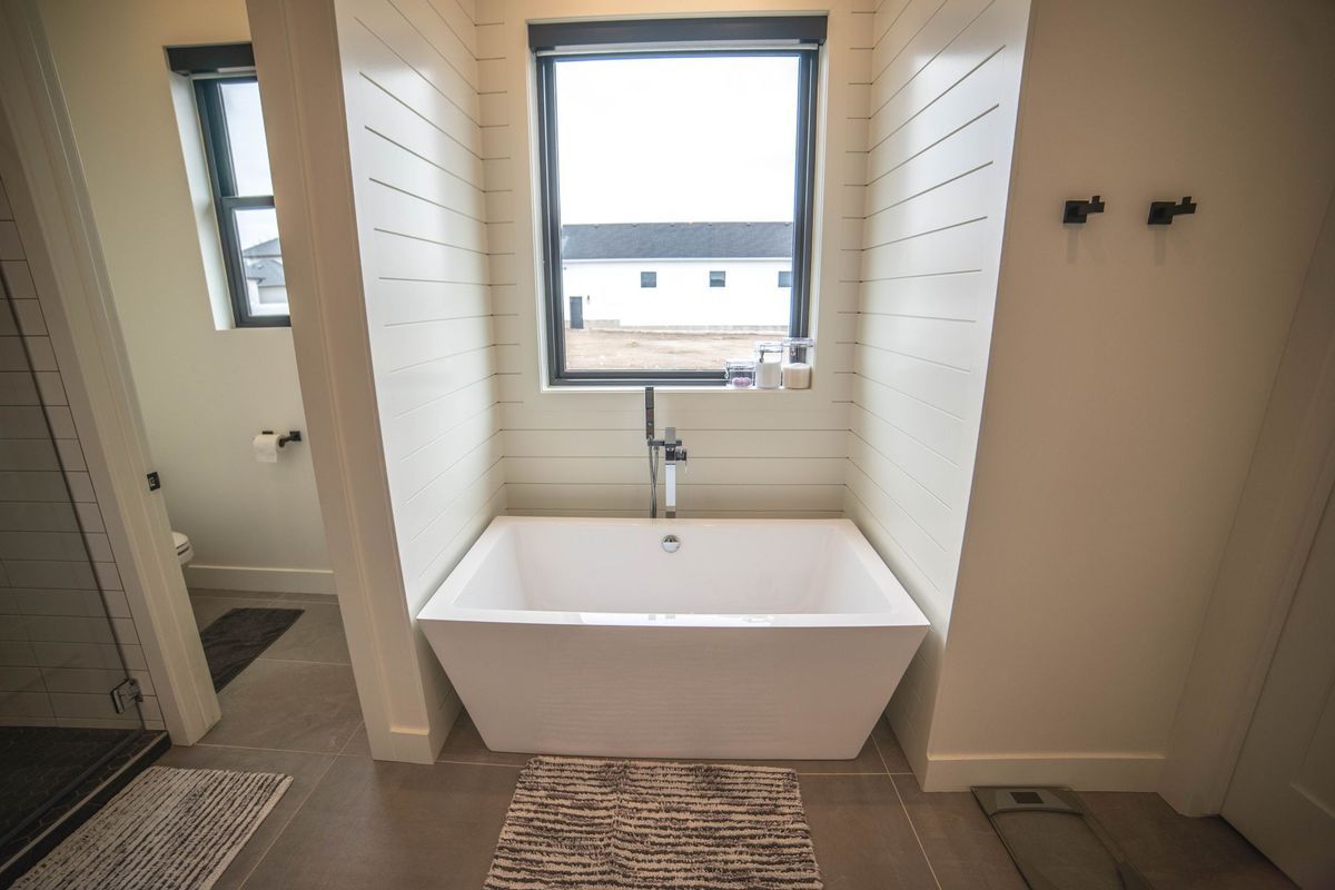 A bathroom with a bathtub and a window.
