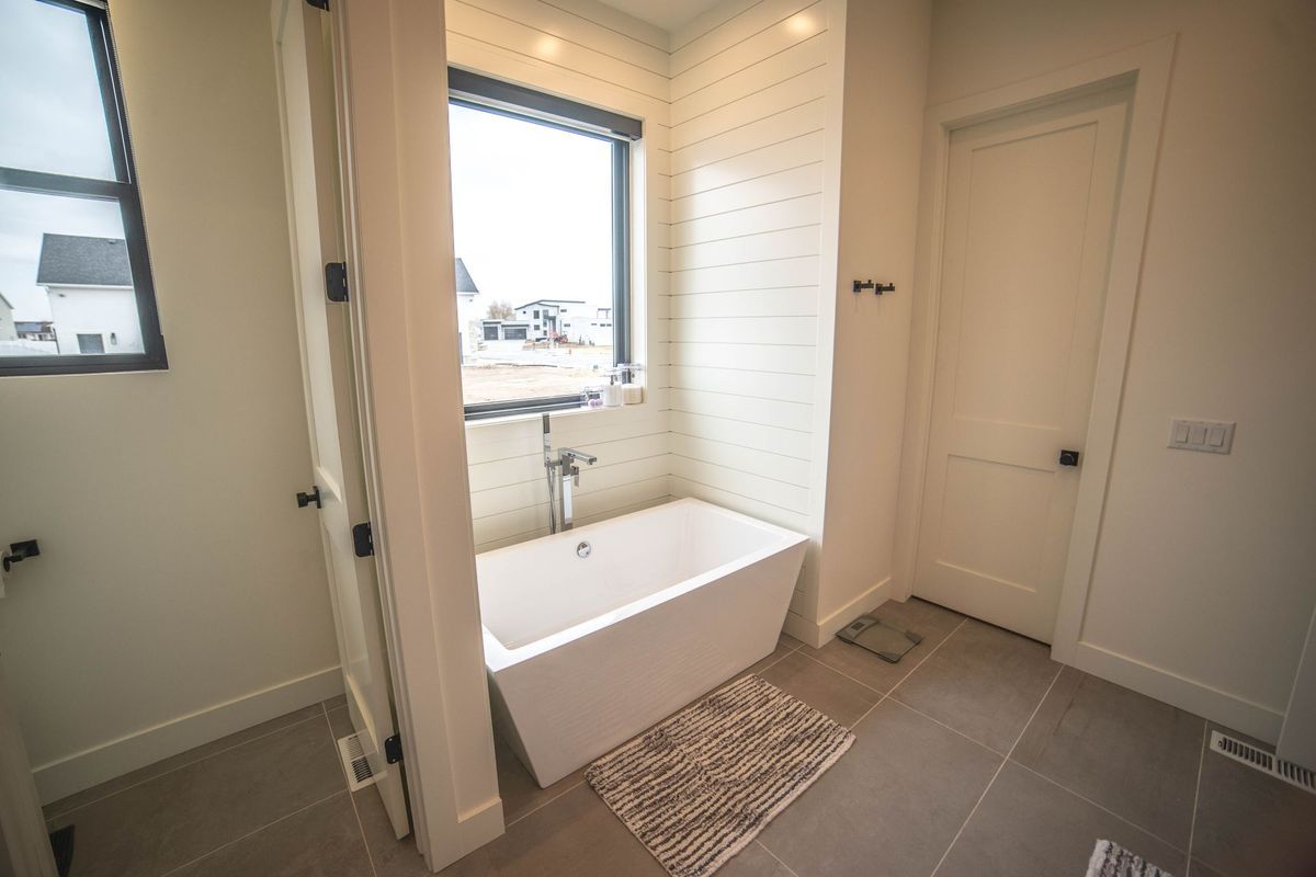 A bathroom with a bathtub and a window.