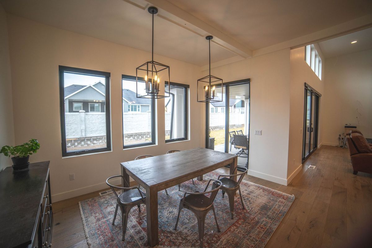 A dining room with a table and chairs and a rug.