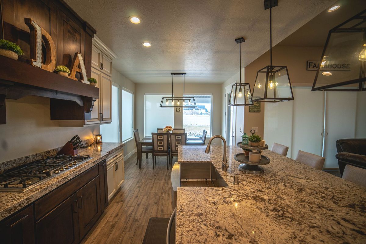A kitchen with granite counter tops and a stainless steel sink.
