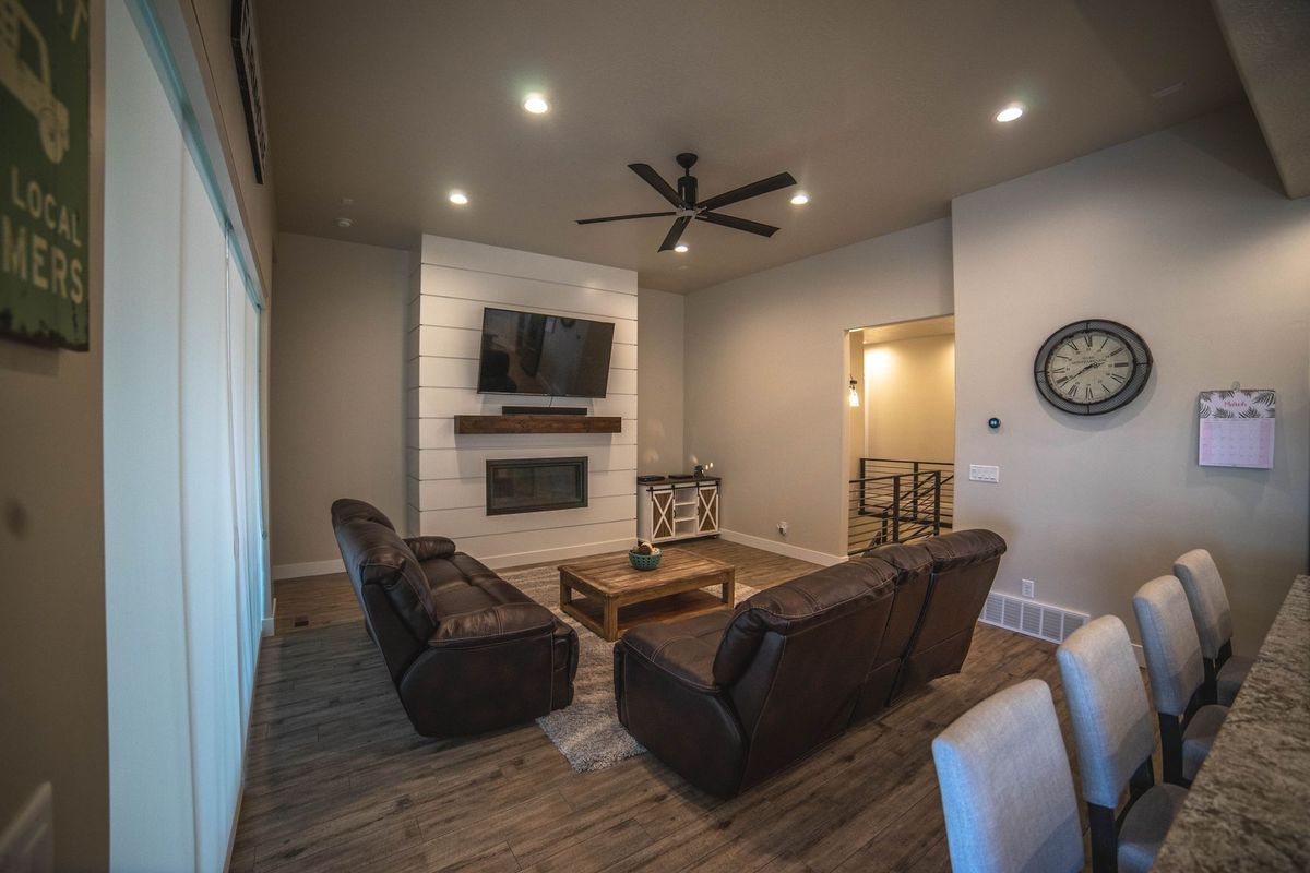 A living room with a fireplace , couch , chairs , table and television.