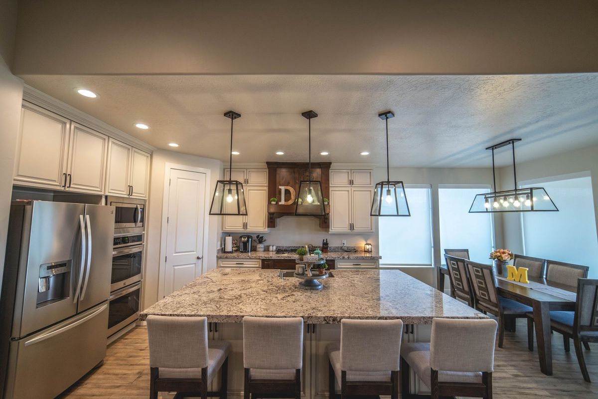 A kitchen with granite counter tops , stainless steel appliances , and a large island.