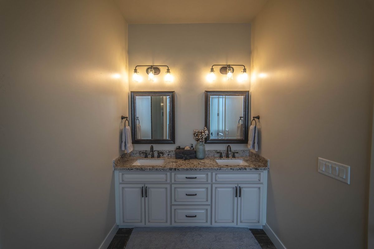 A bathroom with two sinks and two mirrors.